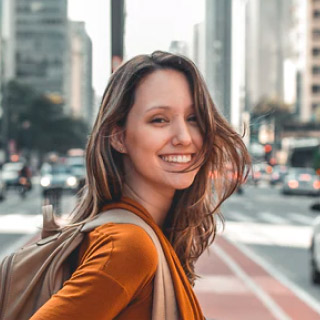 Chica en la calle sonriendo a la cámara